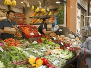 Vibrant scene at Testaccio Market in Rome with vendors selling fresh fruits and vegetables to an engaged elderly female shopper.