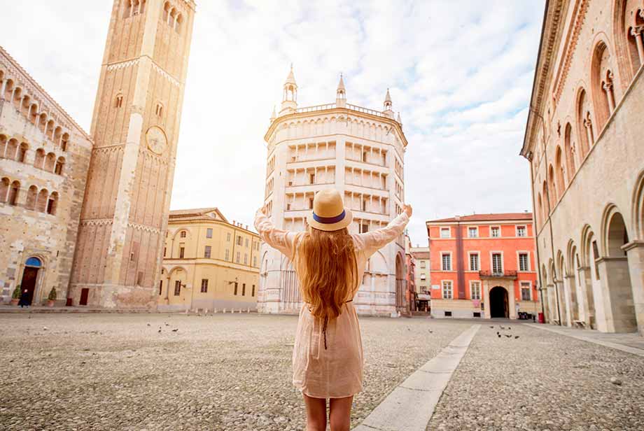 Tourist admiring the historic architecture of Parma City, Italy, featuring the famous Baptistry and Cathedral