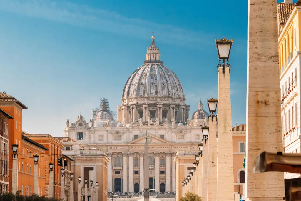 St. Peter’s Basilica and St. Peter’s Square in Vatican City, Rome, Italy, viewed from Via della Conciliazione on a sunny day, a famous European tourist attraction and pilgrimage destination