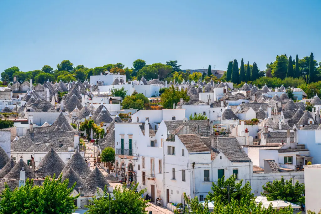 Traditional trulli houses in Alberobello, Puglia, Italy, featuring whitewashed stone buildings with conical roofs and narrow streets, a UNESCO World Heritage site and popular tourist destination in southern Italy