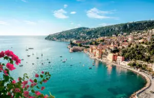 Scenic view of Villefranche sur Mer on the French Riviera, Cote d’Azur, France with colorful seaside buildings, yachts in turquoise Mediterranean waters, and coastal hills between Nice and Monaco