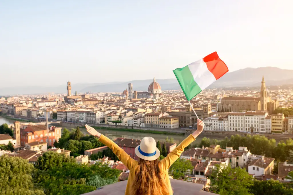 Tourist enjoying panoramic view of Florence Italy with the Italian flag overlooking the Duomo and historic city skyline during a private tour