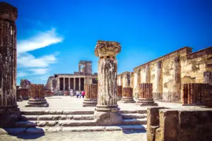 Ancient ruins of Pompeii under a bright blue sky in Italy showcasing historic Roman columns and architecture for Europe private tours