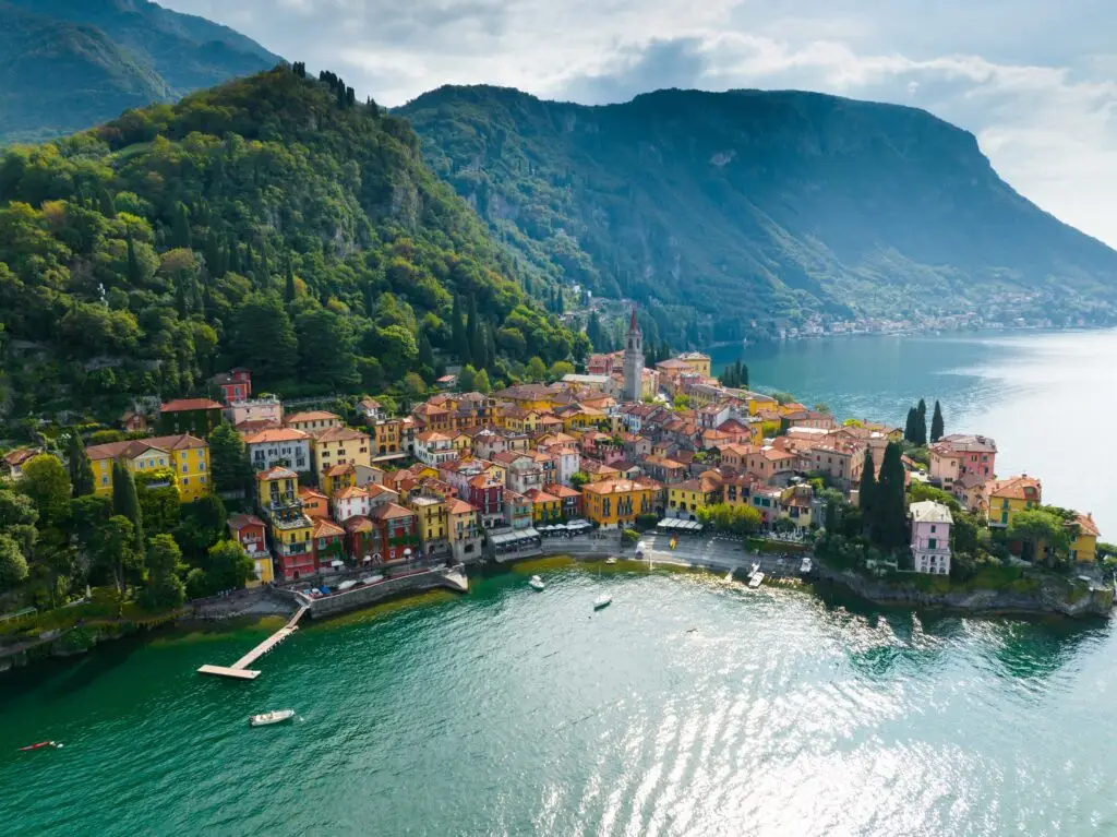 Aerial view of colorful waterfront village of Varenna on Lake Como, surrounded by green mountains in Lombardy, Italy