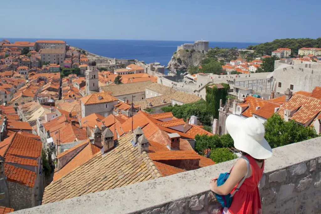 Tourist admiring the scenic view of Dubrovnik Old Town rooftops and city walls, UNESCO World Heritage Site on the Dalmatian Coast, Croatia