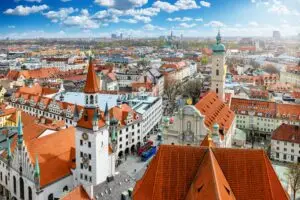 Elevated view of the Munich skyline in Germany with historic architecture, church towers, and city rooftops under a bright blue sky, popular destination for Europe private tours