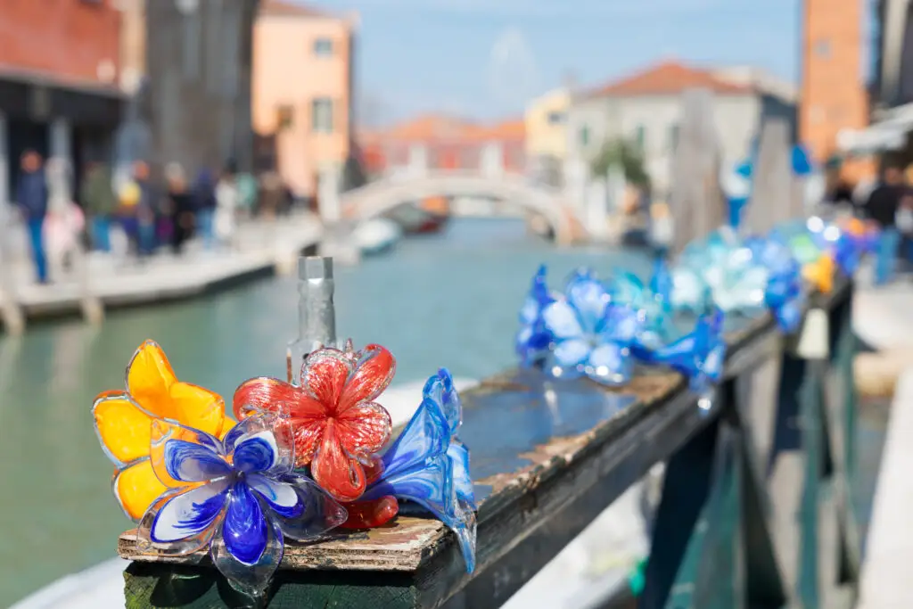 Colorful traditional Murano glass flower decorations along a canal in Murano Island, Venice, Italy