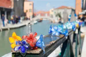 Colorful traditional Murano glass flower decorations along a canal in Murano Island, Venice, Italy