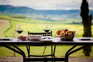 Outdoor Italian lunch with red wine overlooking the rolling Tuscan countryside landscape