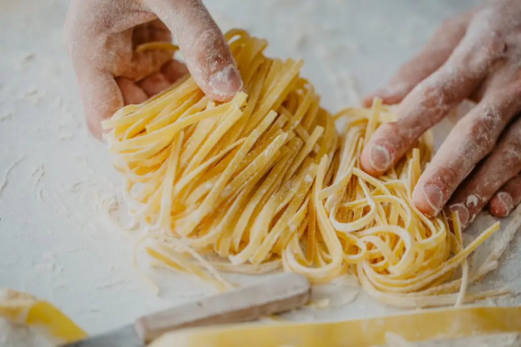 Chef hands making fresh homemade pasta during an Italian cooking class tour