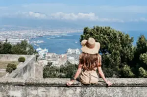 Woman in sun hat overlooking Naples harbor and Mount Vesuvius on a private Italy tour