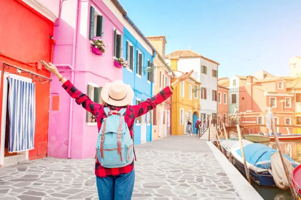 Traveler exploring the colorful canal houses of Burano, Venice, Italy on a private Italy tour