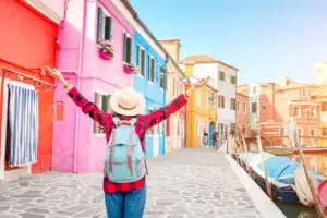 Traveler exploring the colorful canal houses of Burano, Venice, Italy on a private Italy tour