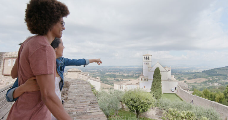 Couple sightseeing in Assisi, Italy, overlooking the Basilica of Saint Francis and Umbrian countryside on a romantic private Italy tour