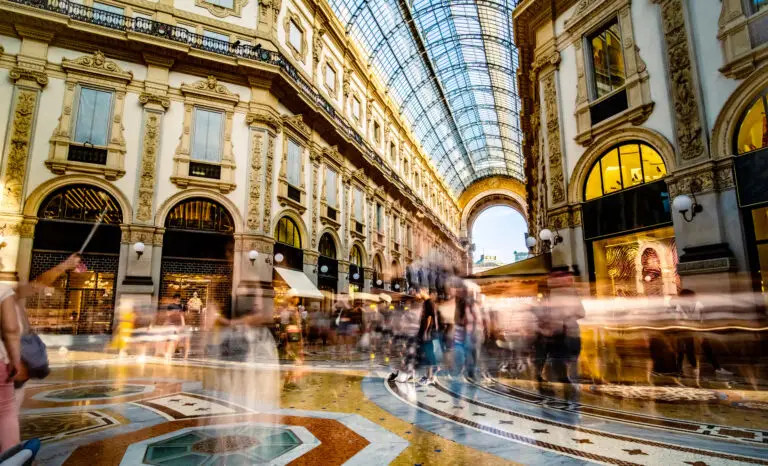Crowded Galleria Vittorio Emanuele II shopping arcade in Milan, Italy with tourists and luxury boutiques