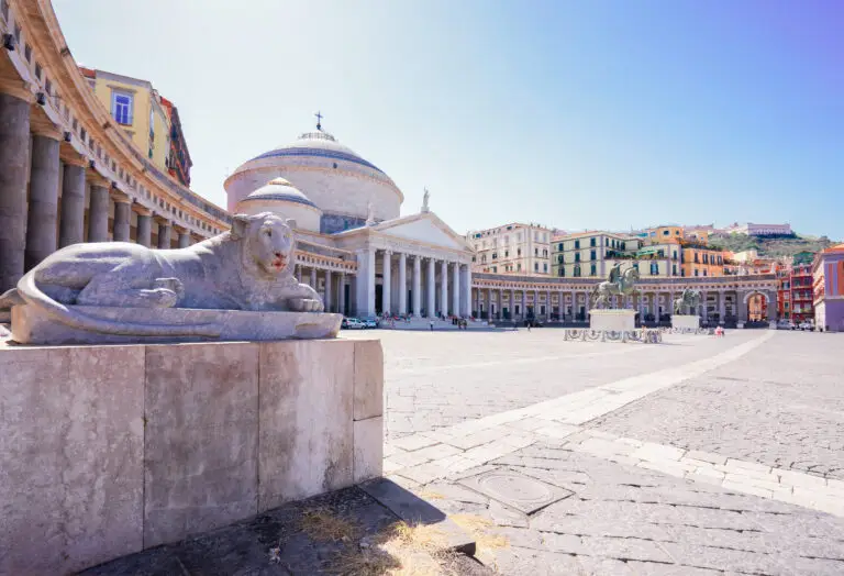 Piazza del Plebiscito in Naples Italy with Basilica of San Francesco di Paola and lion statue on a sunny summer day