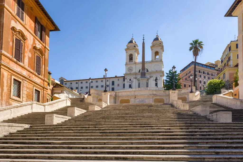 Empty Spanish Steps with Trinità dei Monti church in Rome, Italy under a clear blue sky