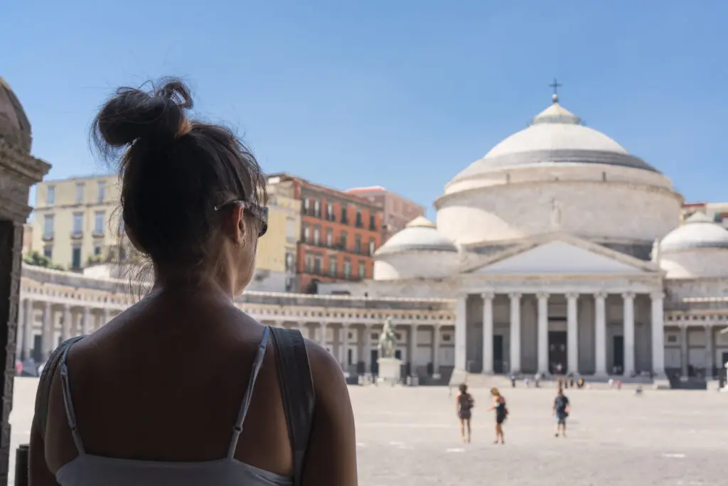 Woman tourist looking at Basilica di San Francesco di Paola in Piazza del Plebiscito, Naples, Italy