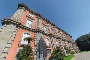 Exterior of the Royal Palace of Capodimonte in Naples Italy with historic architecture and palm trees in Capodimonte Park