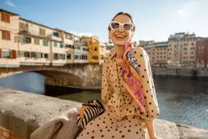 Young woman enjoying the view of Ponte Vecchio bridge in Florence, Italy during a private Italy tour