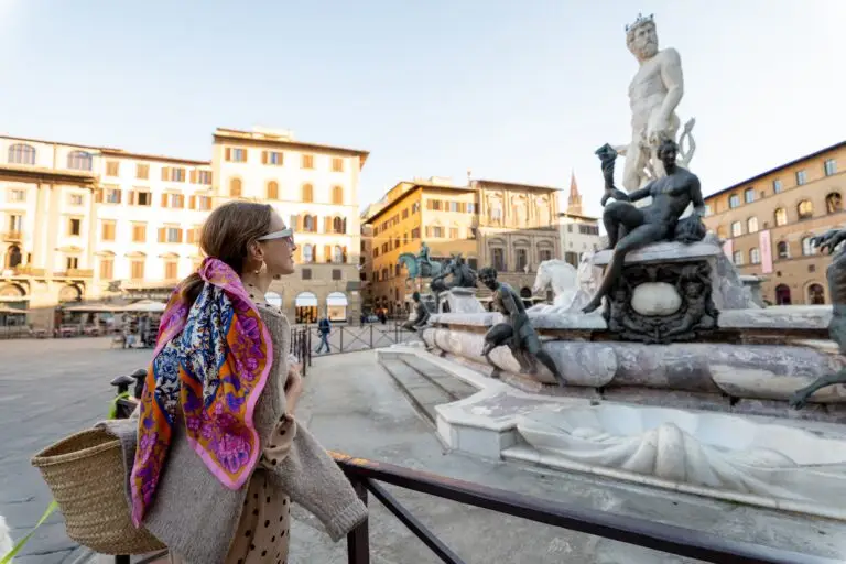 Woman tourist admiring the Fountain of Neptune in Piazza della Signoria during a Florence Italy tour
