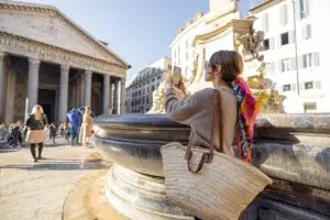 Young female traveler photographing the Pantheon and fountain in Rome, Italy on a private Italy tour