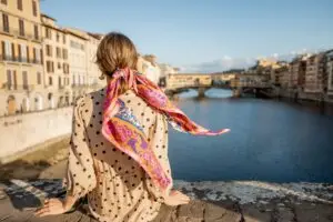 Young woman admiring Ponte Vecchio and the Arno River in Florence, Italy