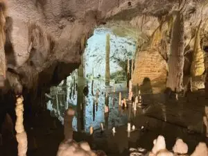 Inner lake inside Grotte di Frasassi karst cave in Italy with dramatic stalactites and stalagmites reflected in the water