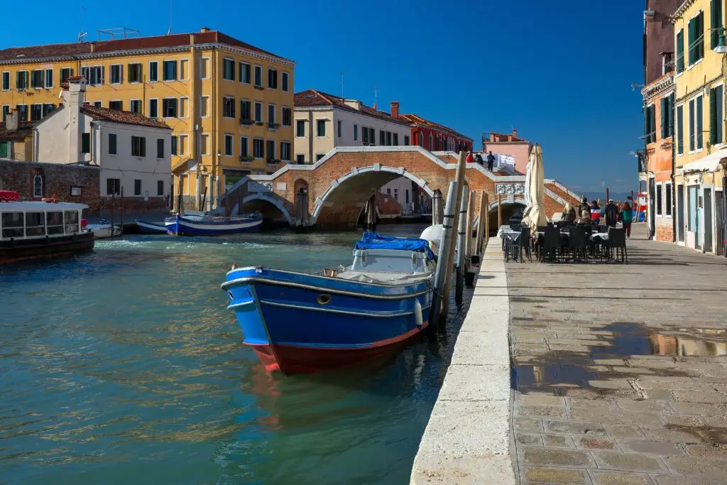 Cannaregio canal with Ponte dei Tre Archi bridge and boats in Venice, Italy