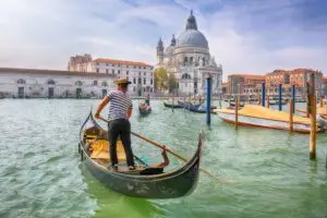 Gondola ride on the Grand Canal in Venice, Italy, with Basilica di Santa Maria della Salute in the morning cityscape