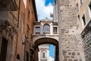 Historic old street in Trastevere, Rome, Italy with stone buildings and a covered walkway for private Italy tours