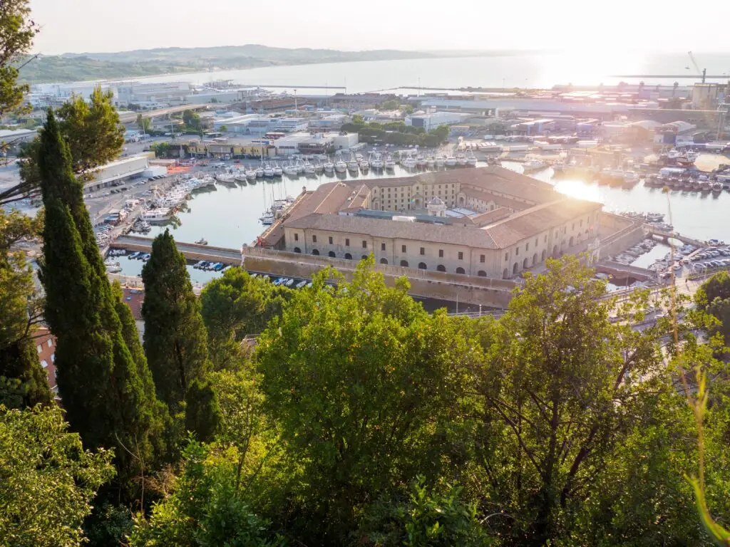 Scenic view of the Port of Ancona in Le Marche, Italy, with marina boats and historic waterfront buildings at sunset