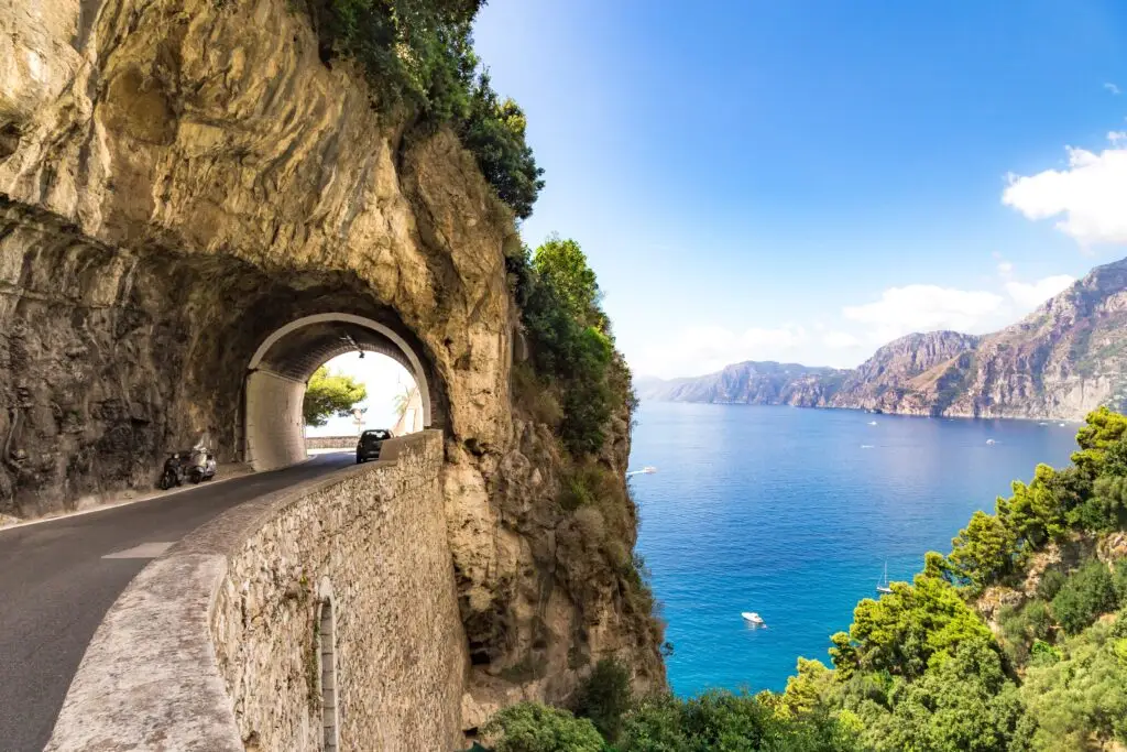 Scenic cliffside road and tunnel overlooking the Amalfi Coast in Italy with blue sea and mountain views