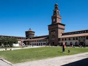 Castello Sforzesco medieval fortress in Milan, Italy with central tower and courtyard under blue sky