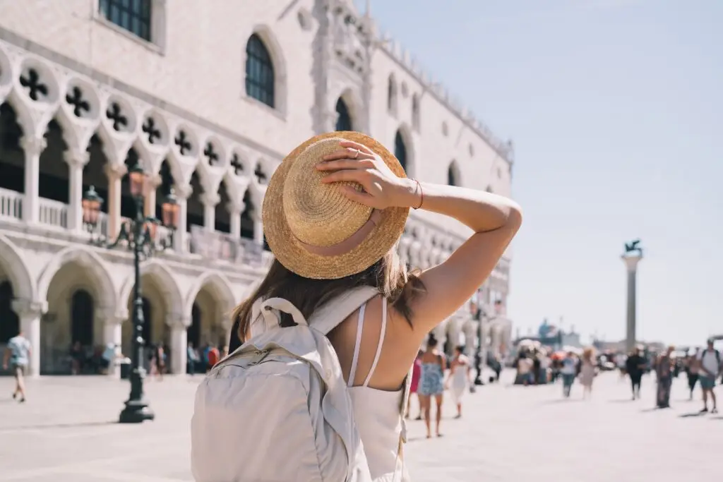 Young woman tourist with backpack visiting Doge’s Palace in Venice, Italy on a private Italy tour