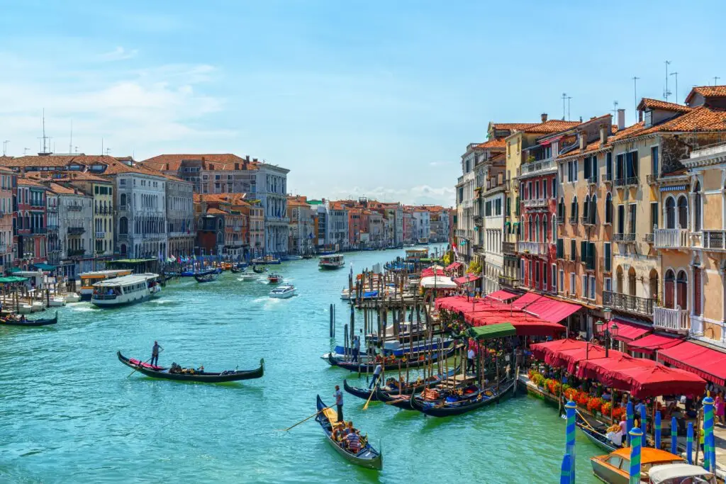 Beautiful view of the Grand Canal in Venice, Italy with gondolas, historic buildings, and waterfront cafes