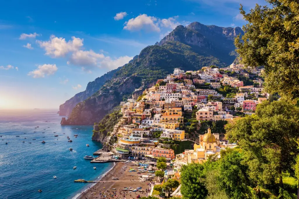 View of Positano on the Amalfi Coast in Italy with colorful cliffside houses, beach, boats and blue sea