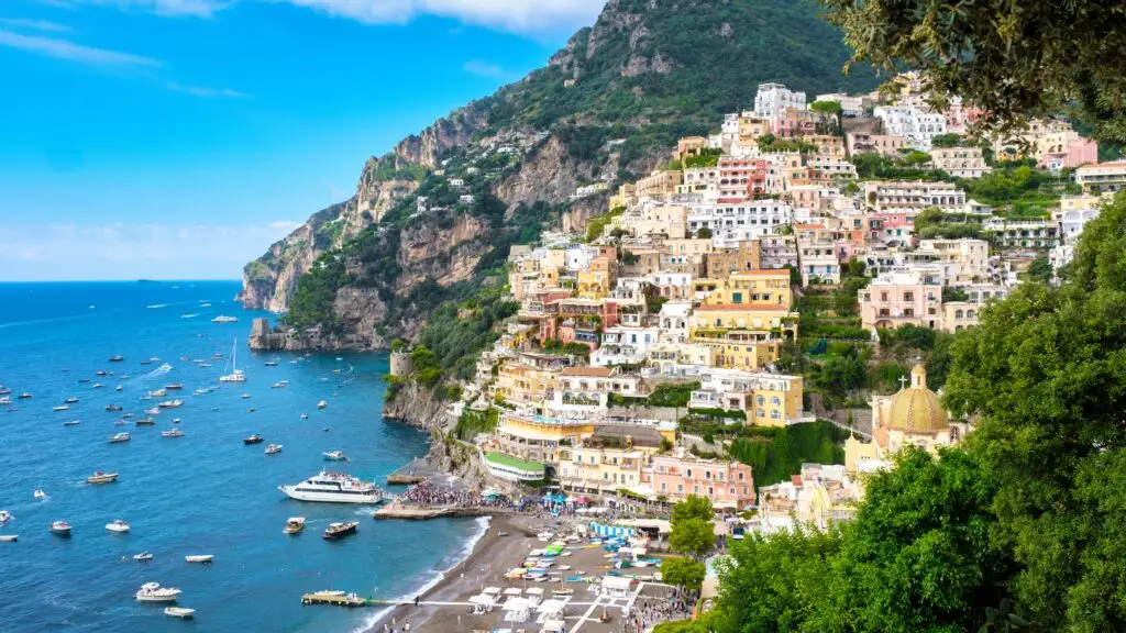 Colorful cliffside houses and boats overlooking the Amalfi Coast in Positano, Italy