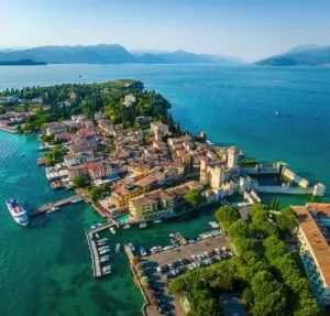 Aerial view of Sirmione on Lake Garda, Italy, with Scaliger Castle, historic town, turquoise water and mountains in the distance