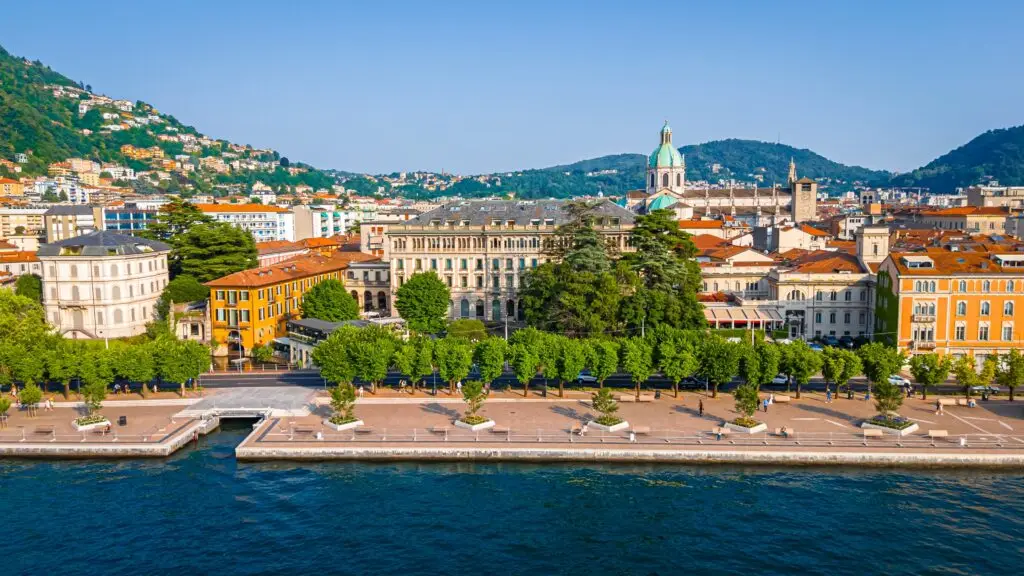 Aerial summer view of Como village on Lake Como in northern Italy with historic waterfront buildings and green hills