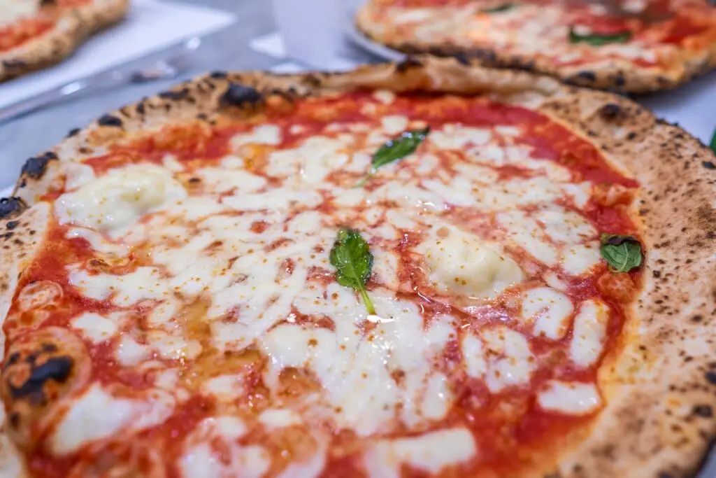 Traditional Neapolitan Margherita pizza with mozzarella, tomato sauce and basil in Naples Italy
