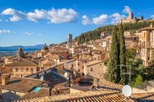 Assisi Italy hilltop old town skyline with medieval rooftops, bell tower and Rocca Maggiore fortress in Umbria