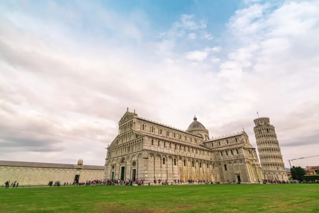 Leaning Tower of Pisa and Pisa Cathedral in Piazza dei Miracoli, Italy at twilight with tourists on a private Italy tour