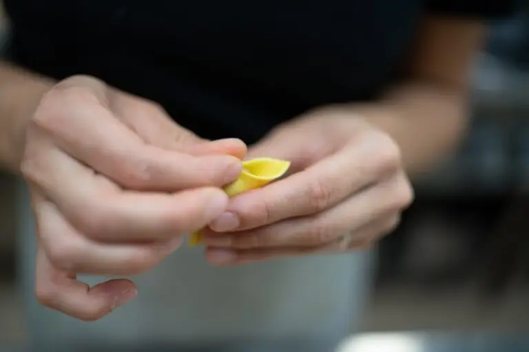 Chef shaping fresh tortelli pasta by hand during an authentic Italian cooking experience in Italy