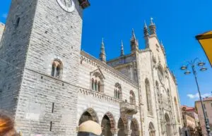 Como Cathedral Duomo di Como historic church facade and bell tower in Como, Italy under blue sky