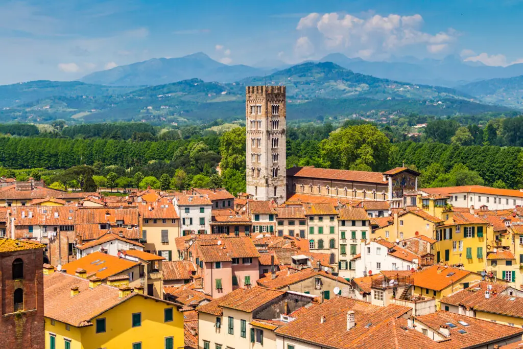 Panoramic view over Lucca, Italy with terracotta rooftops, San Frediano bell tower and Tuscan hills in the background