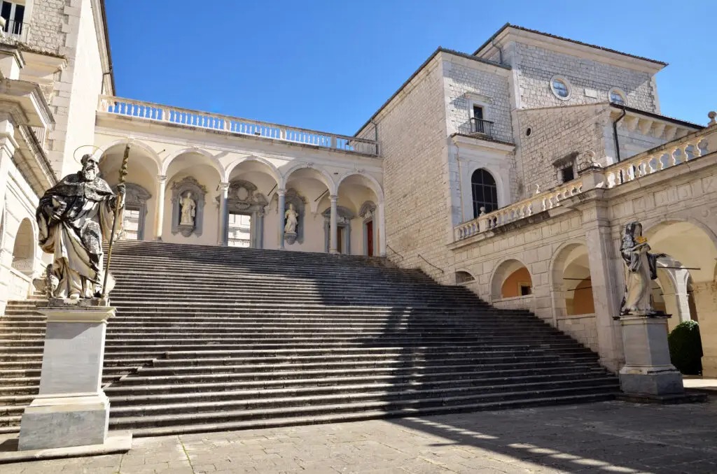 Benedictine Abbey of Montecassino in Cassino Italy with grand staircase and statues under blue sky