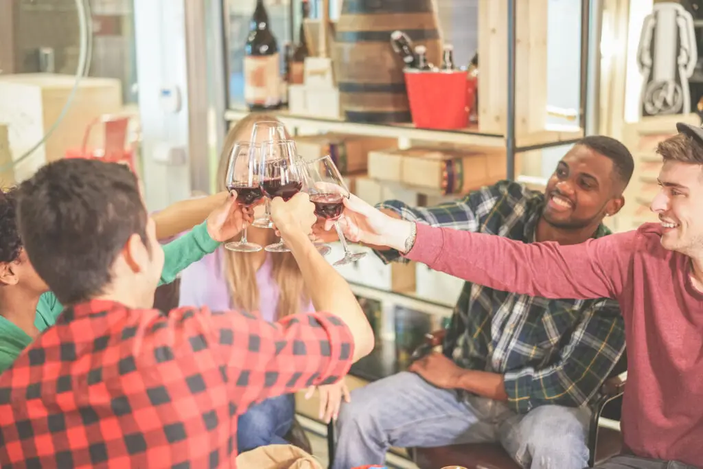 Diverse friends cheering with red wine during a winery tasting on a private Italy wine tour