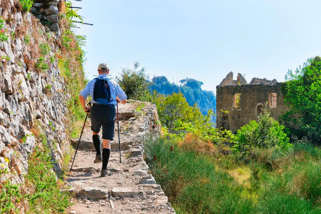 Hiker with backpack and Nordic walking poles on the Path of the Gods trail on Italy’s Amalfi Coast