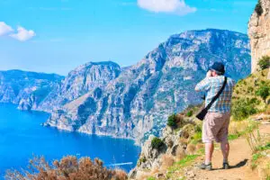 Man taking photos of Amalfi Coast scenery from the Path of the Gods hiking trail in Italy